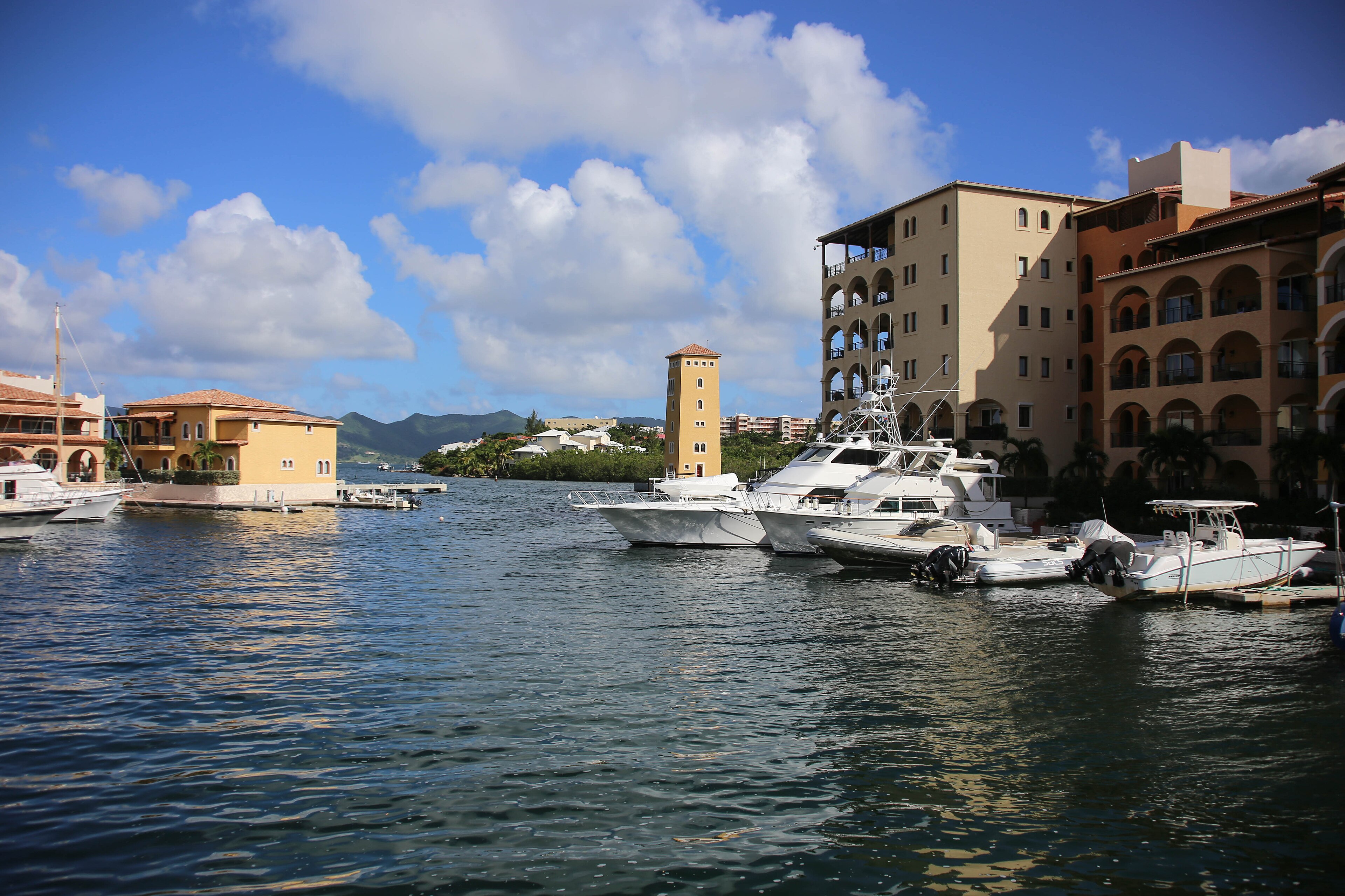 Yachts and ochre apartment buildings around the marina at Porto Cupecoy, Sint Maarten